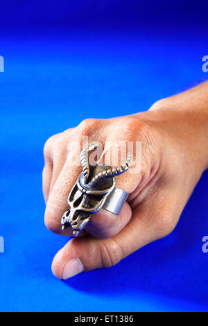 Bague mode moderne sur fond bleu ; doigts ; Bombay Mumbai Maharashtra ; Inde ; M.# 201 Banque D'Images