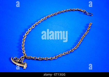 Collier avec pendentif amulette en métal sur fond bleu Banque D'Images