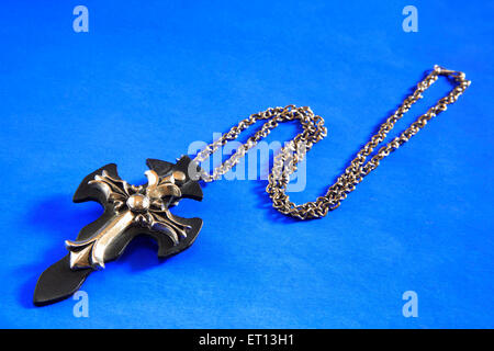 Collier avec pendentif en croix amulette sur fond bleu Banque D'Images