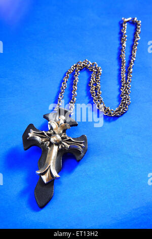 Collier avec pendentif en croix amulette sur fond bleu Banque D'Images