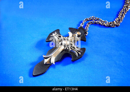 Collier avec pendentif en croix amulette sur fond bleu Banque D'Images