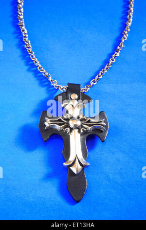 Collier avec pendentif en croix amulette sur fond bleu Banque D'Images