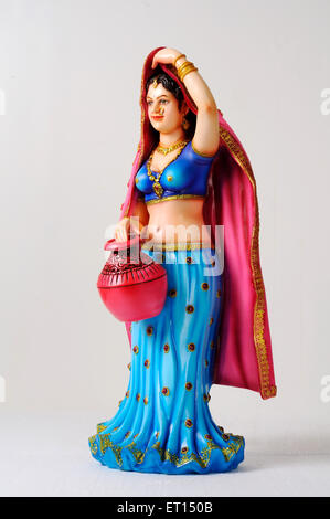Figurine en argile ; statue de jeune fille rajasthani avec sari pallu sur sa tête, et la holding pot coloré Banque D'Images
