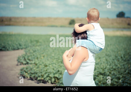 Femme enceinte avec garçon sur son cou Banque D'Images