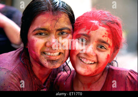 Sisters hugging toucher joues célébrer Holi Festival des couleurs de l'Inde M.# 364 Banque D'Images