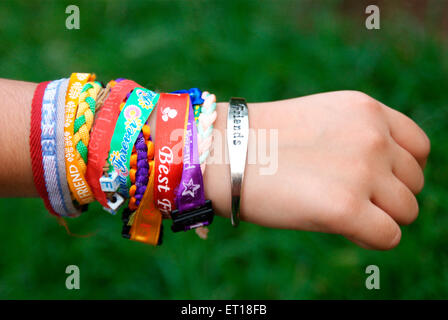 Les bandes de l'amitié bracelets attachés sur fond vert à la main - M.# 364 - Banque D'Images