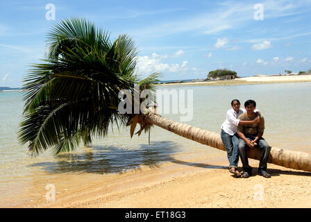 Couple sitting on palm tree à Radhanagar beach Îles Havelock-Inde - M.# 736J&K Banque D'Images