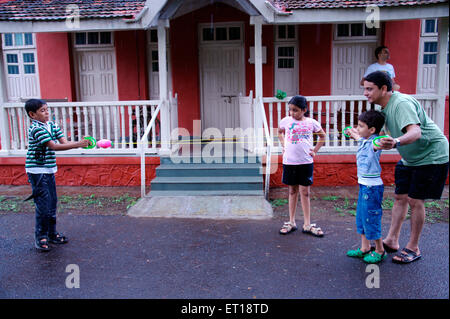 Père de famille et enfants jouant nouveau jeu avec cordes et ball in front of house - M.# 364 smr - 179832 Banque D'Images