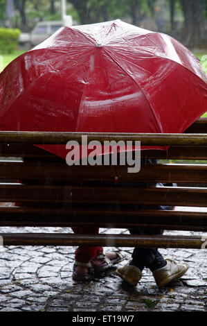 Young Couple mousson en Asie Inde Mumbai un parapluie Banque D'Images