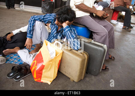 Homme dormant sur sac ; plate-forme ferroviaire ; Surat ; Gujarat ; Inde ; Asie Banque D'Images