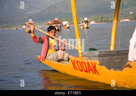 L'aviron en garçon shikara dal lake, à Srinagar, Jammu-et-Cachemire ; Inde ; Banque D'Images