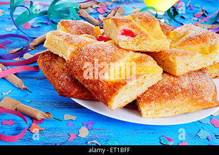 Certains d'artifice et une assiette avec des morceaux de la coca de Sant Joan, une galette sucrée typique de la Catalogne, Espagne, mangé sur Saint Banque D'Images