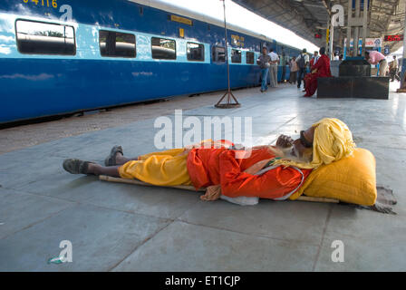 Prêtre reposant sur une plate-forme, gare d'Habibganj ; Bhopal ; Madhya Pradesh ; Inde Banque D'Images