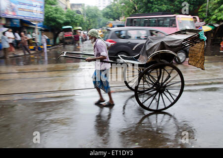 Man pulling pousse-pousse sur Main Street à New Delhi à l'ouest du Bengale en Inde Asie Banque D'Images