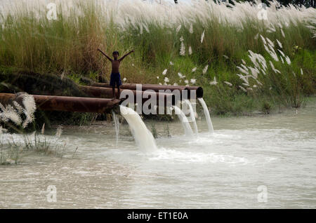 Garçon debout sur la chute de pipeline en étang Kolkata West Bengal India Asie Banque D'Images