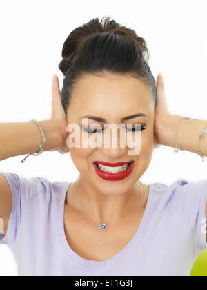 Portrait d'une belle jeune femme hispanique dans la vingtaine couvrant ses oreilles pour bloquer le bruit et les sons Banque D'Images