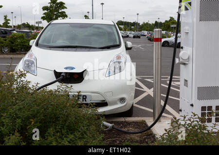 Une Nissan Leaf voiture électrique d'être rechargé à Cobham Services sur la M25, Surrey, England, UK Banque D'Images