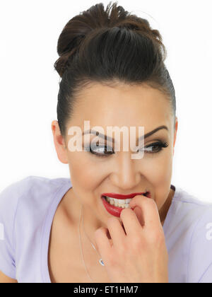 Portrait d'une belle jeune femme hispanique nerveux de mordre ses ongles dans la peur sur un fond blanc. Banque D'Images