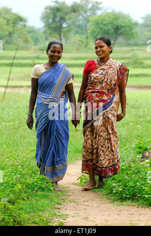 Les femmes de la tribu Ho marchent main dans la main ; Chakradharpur ; Jharkhet ; Inde ; la tribu indienne Ho Hodoko Horo Banque D'Images