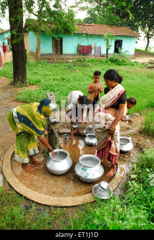 Ho les femmes des tribus des pots avec de l'eau de remplissage par pompe à Chakradharpur ; ; ; Inde Jharkhand PAS MR Banque D'Images