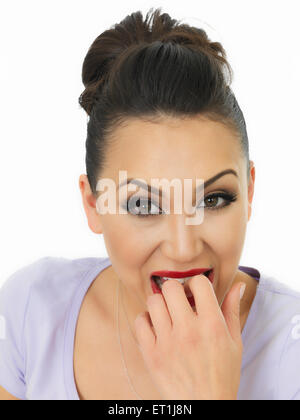 Portrait d'une belle jeune femme hispanique nerveux de mordre ses ongles dans la peur sur un fond blanc. Banque D'Images