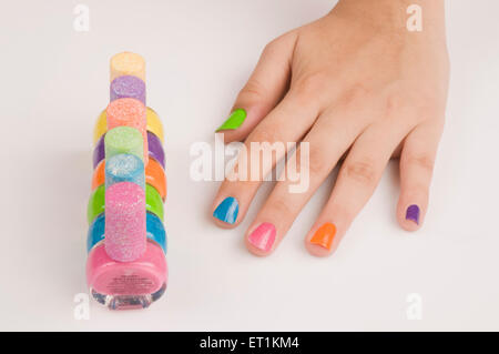 doigts avec des bouteilles de vernis à ongles de différentes couleurs Banque D'Images