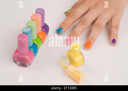 doigts avec des bouteilles de vernis à ongles de différentes couleurs Banque D'Images