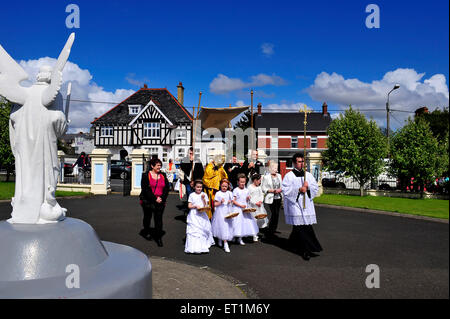 Les prêtres catholiques à la tête d'une procession dans Hammerfest dans le comté de Donegal, Irlande sur la fête du Corpus Christi. Banque D'Images