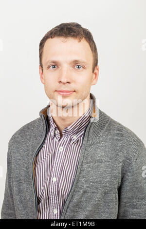 Young smiling Caucasian man en vêtements, studio portrait sur fond gris Banque D'Images