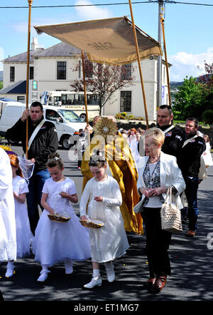 Un prêtre catholique à la tête d'une procession dans Hammerfest dans le comté de Donegal, Irlande sur la fête du Corpus Christi. Banque D'Images