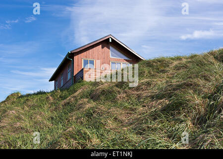 Maison traditionnelle danoise dans les dunes de sable avec ciel bleu et vert herbe Banque D'Images