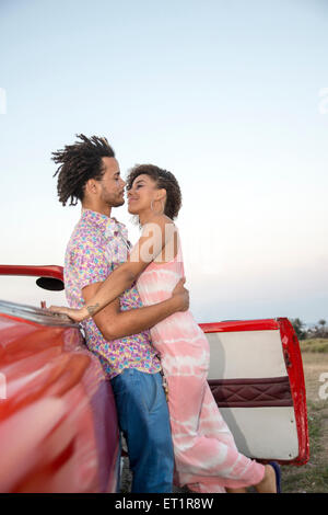 Lain couple dans une voiture de collection sur le coucher du soleil Banque D'Images