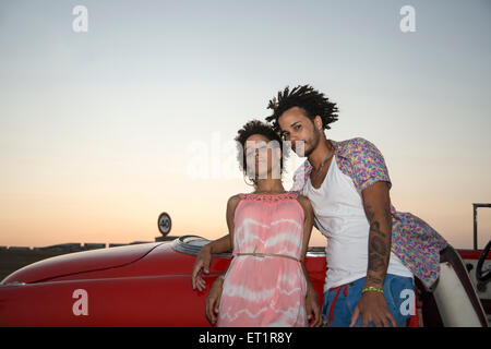 Lain couple dans une voiture de collection sur le coucher du soleil Banque D'Images
