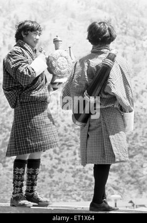 Jeunes hommes en tenue bhoutanaise traditionnelle ; Thimpu ; Bhoutan ; Asie ; ancienne image millésime des années 1900 Banque D'Images