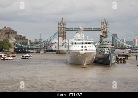 Bateau de croisière amarré à côté de HMS Belfast sur la Tamise, Londres UK Banque D'Images