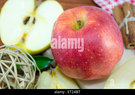 Moitié et l'ensemble de la pomme rouge sur une table avec une décoration faite à la main Banque D'Images