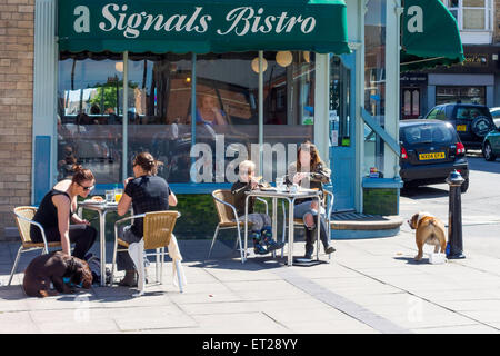 Les clients avec les chiens appréciant leur petit-déjeuner au soleil d'été au Bistro des signaux par la mer Saltburn North Yorkshire Angleterre Banque D'Images