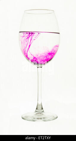 Quelques grains de permanganate de potassium sont dissous dans l'eau Banque D'Images