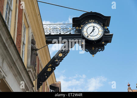 Une vieille horloge décorative monté sur le mur d'un bâtiment à Winchester, Royaume-Uni Banque D'Images
