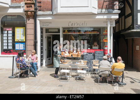 Le Caracoli cafe et un café dans le centre-ville de Winchester UK avec les gens boire et manger à des tables sur le trottoir Banque D'Images