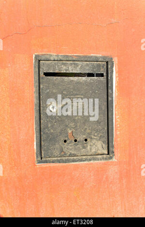 Ancienne boîte aux lettres rouillée sur orange wall Banque D'Images