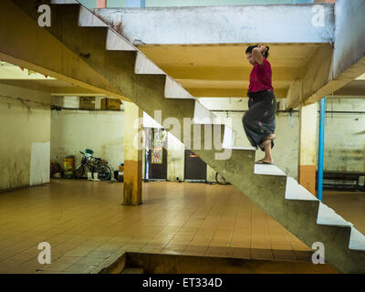 Mahachai, Samut Sakhon, Thaïlande. 11 Juin, 2015. Un travailleur migrant birman retourne à son appartement dans un immeuble qui abrite de migrants birmans. Les militants ouvriers disent qu'il y a environ 200 000 travailleurs migrants en provenance du Myanmar (Birmanie) à l'emploi dans l'industrie de la pêche et des fruits de mer à Mahachai, un port de pêche d'environ une heure au sud-ouest de Bangkok. Depuis 2014, la Thaïlande a été un pays de niveau 3 sur le département d'état des rapport sur la traite des personnes (TIPS). Niveau 3 est le plus mauvais classement, étant un pays de niveau 3 sur la liste peut entraîner des sanctions. Pays de niveau 3 sont ''Les pays dont les gouvernements Banque D'Images