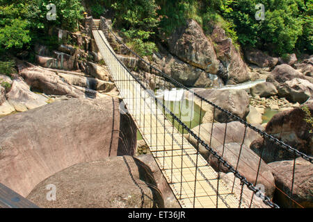 Pont suspendu dans une vallée au-dessus de la rivière. Banque D'Images