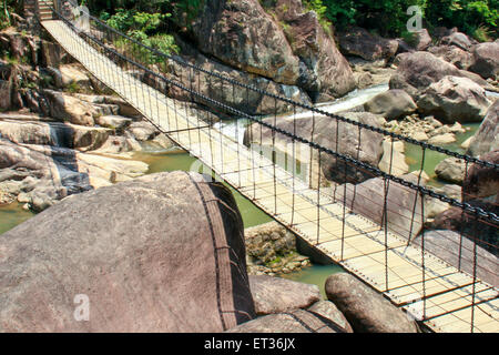 Pont suspendu dans une vallée au-dessus de la rivière. Banque D'Images