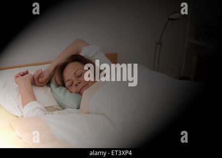 Senior woman sleeping on lit dans la chambre, Munich, Bavière, Allemagne Banque D'Images