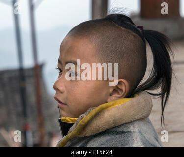 Basha garçon Miao traditionnel avec le crâne rasé et début d'un chignon, Basha Village des armes à feu, la province du Guizhou, Chine Banque D'Images