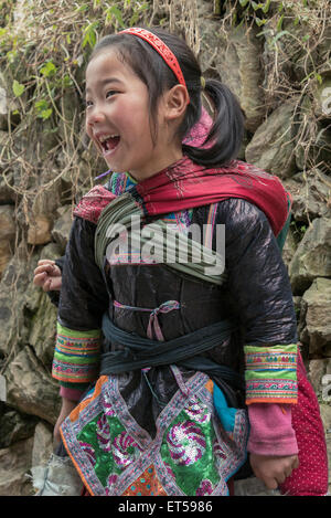 Smiling girl Miao avec jeune frère à peine visible sur son dos, Basha Village des armes à feu, la province du Guizhou, Chine Banque D'Images