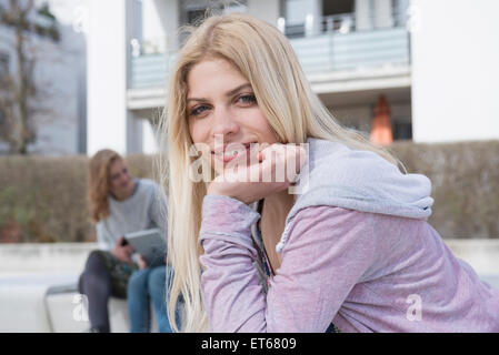 Portrait of teenage girl avec ses amis à l'aide de tablette numérique à l'arrière-plan, Munich, Bavière, Allemagne Banque D'Images