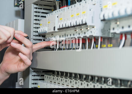 Close-up of electrician vissant en distribution par câble fusebox, Munich, Bavière, Allemagne Banque D'Images