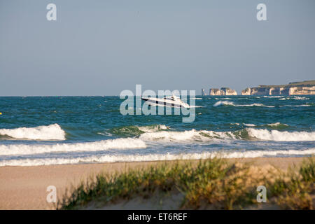 Bateau de Moteur Sunseeker avec Old Harry Rocks dans la distance de la plage de Sandbanks, Poole, Dorset, UK en Juin Banque D'Images